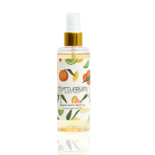 A clear spray bottle labeled Tutti Frutti Body Mist with a design featuring various fruits.