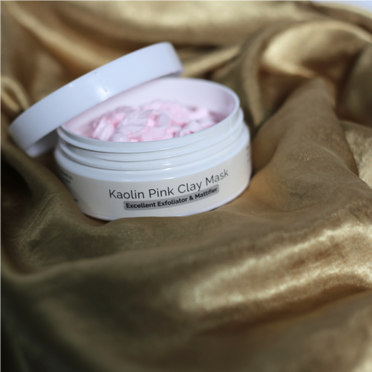 Soft clay mask in jar beside kaolin clay and flower petals