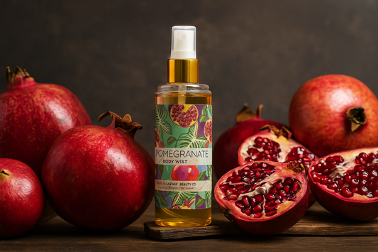 Pomegranate body mist bottle with pomegranates on a wooden surface