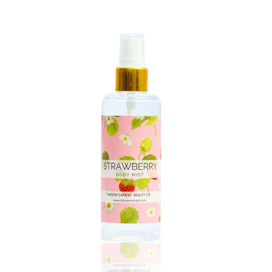 A clear spray bottle labeled Strawberry Body Mist with an image of strawberries and green leaves on the label, indicating the scent of the product.