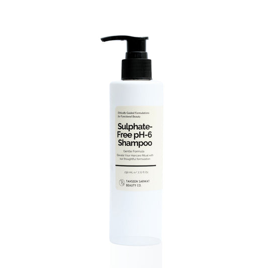 A pump bottle of sulphate-free pH-6 shampoo against a white . Close-up of Sulfate-Free pH 6 Shampoo bottle with a clean, minimal design and neutral background. background.