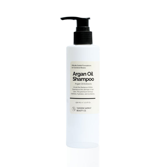 A bottle of Argan Oil Shampoo with a pump dispenser, predominantly white label with black text and accents, displayed against a plain background.