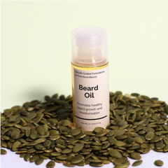 Beard oil dropper with visible serum drops and ingredients like almond oil and vitamin E and pumkin seeds