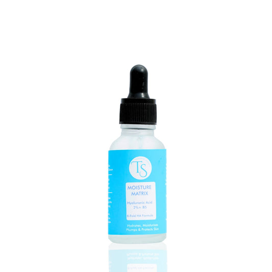 A clear glass bottle with a dropper containing blue liquid, labeled as Moisture Matrix Hyaluronic Acid Serum.