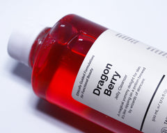 Cleanser tube beside charcoal and fruit ingredients, highlighting pore care